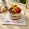 Bánh tiramisu sinh nhật nhiều lớp trang trí dâu tây, nho, cam và lời chúc trên đế bánh